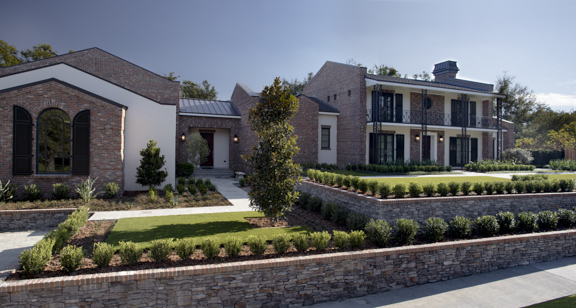 A house with a well manicured lawn and a stone wall represented at 2018 TNAR show